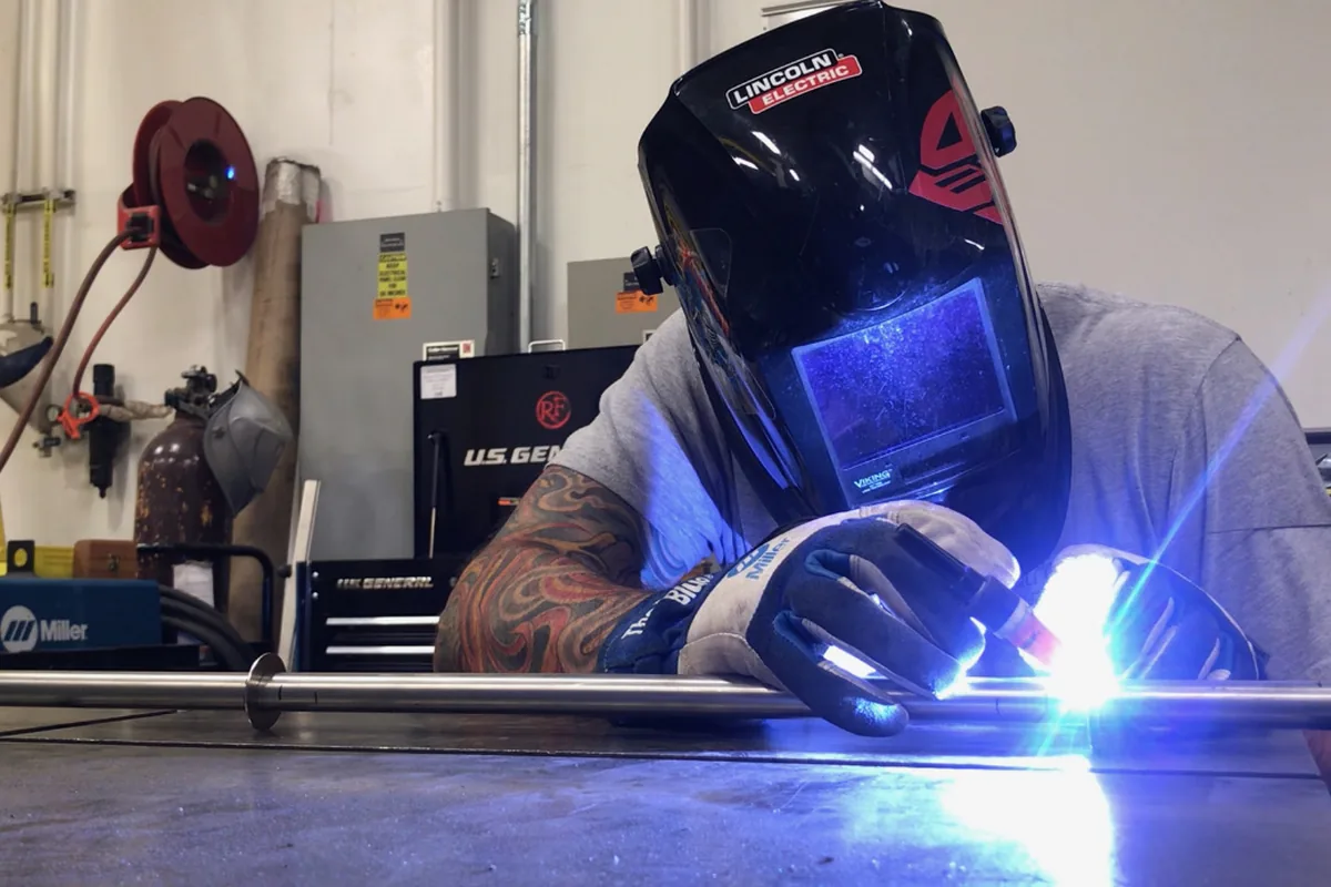 Technician TIG welding a steel tube in the fabrication shop